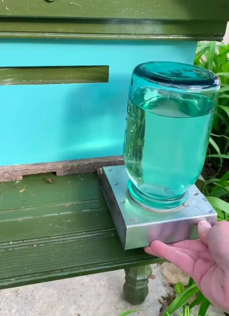5 Best Bee Feeders: Reviews, Comparisons & Buying Guide 9 Bee feeder installed on a beehive with honey bees gathering around the entrance