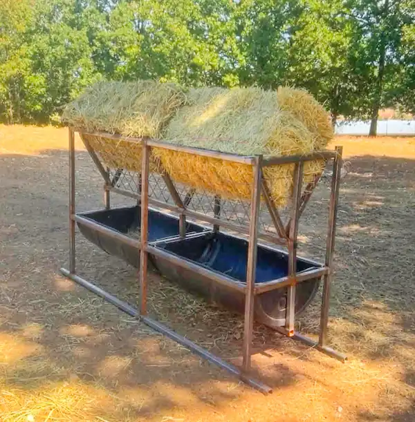 8 Best Goat Feeders: Hay, Grain, Mineral & DIY Options 6 Raised goat hay rack and trough feeder holding a large amount of hay